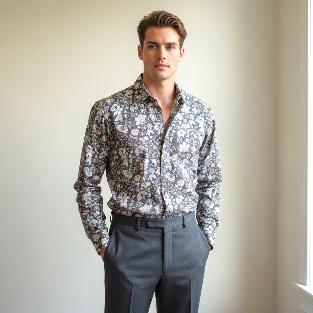 May include: A long-sleeved button-down shirt with a floral pattern in shades of gray, white, and yellow. The shirt is paired with gray dress pants. The model is standing in front of a neutral background.