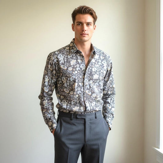 May include: A long-sleeved button-down shirt with a floral pattern in shades of gray, white, and yellow. The shirt is paired with gray dress pants. The model is standing in front of a neutral background.